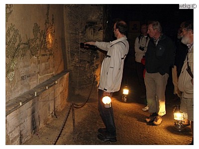De excursieleider geeft aan waar de K-T-grens in grotten te zien is.